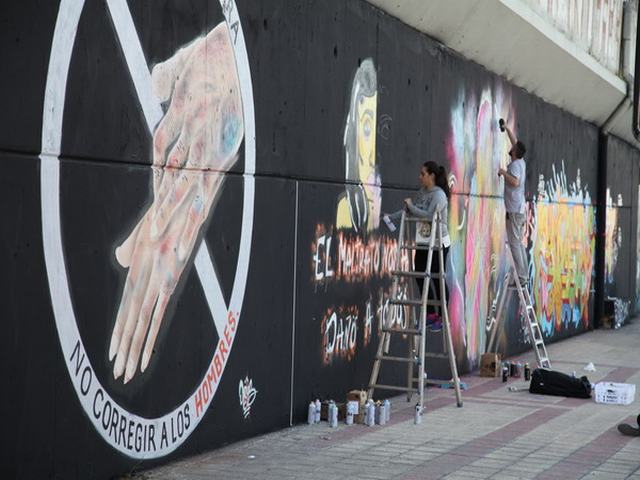Graffitis contra el machismo decoran el muro de la vía en la calle Ferrocarril
